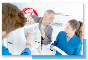 three people looking at an AC unit
